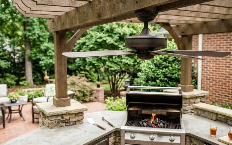 Wet-rated ceiling fan installed in a covered outdoor kitchen with exposed beam ceiling